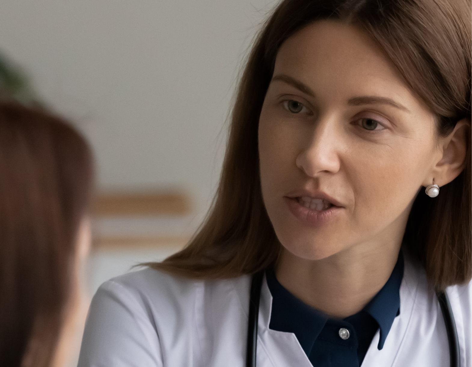 female doctor wearing stethoscope talking to patient