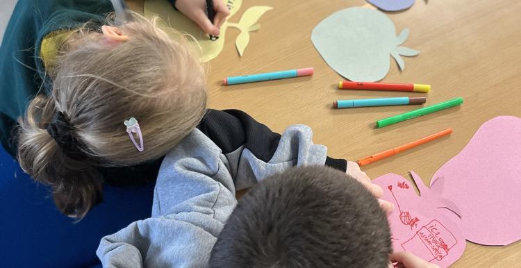 two young carers sat writing at a table