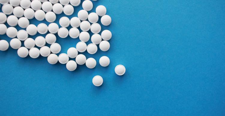 pile of white pills on blue background