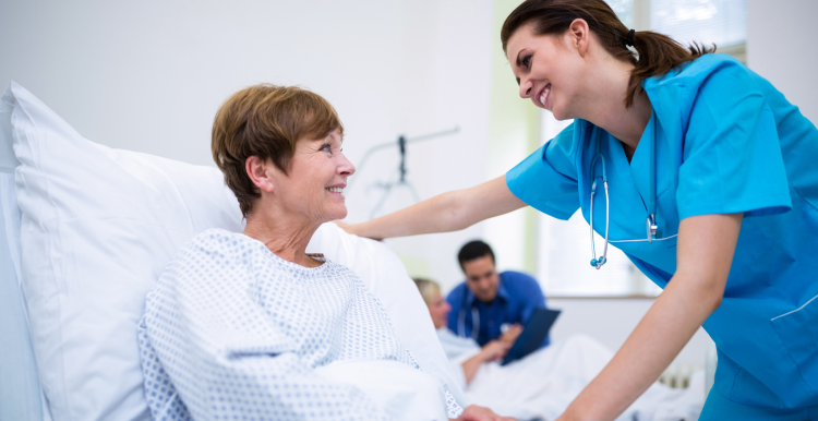 female doctor attending female patient in hospital bed