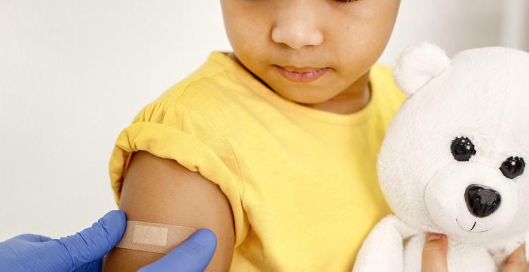 child looking down at plaster on their arm