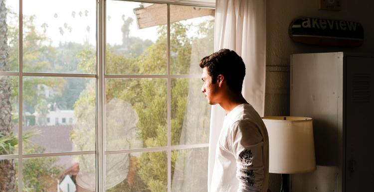 man looking out of window