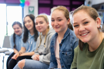 group of girls sitting in a row