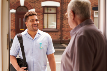 volunteer stood on older man's doorstep