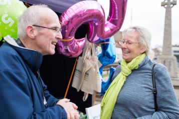 Elderly man and woman talking together at a Healthwatch event