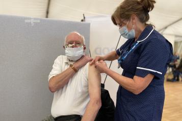 Nurse giving Covid vaccine to man