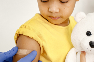 child looking down at plaster on their arm