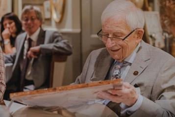 man sitting at a table looking at a picture