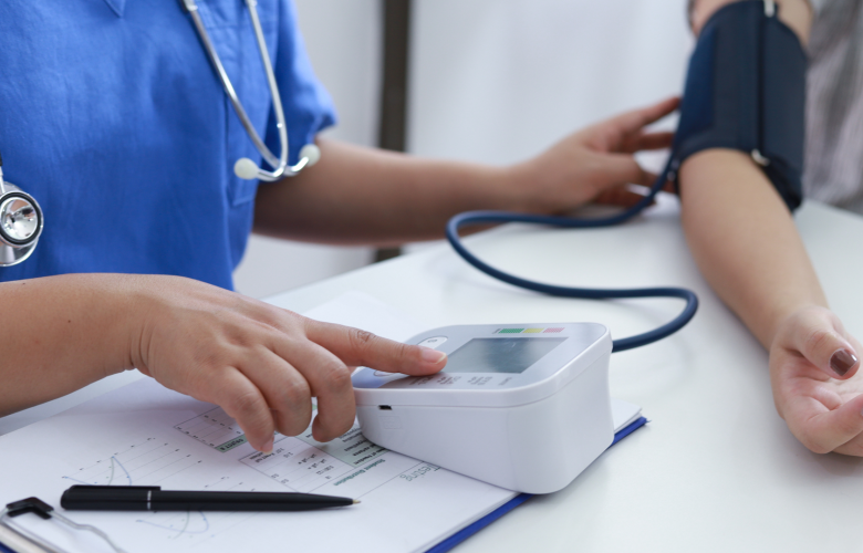 A doctor checking a woman's blood pressure.