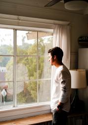 man looking out of window